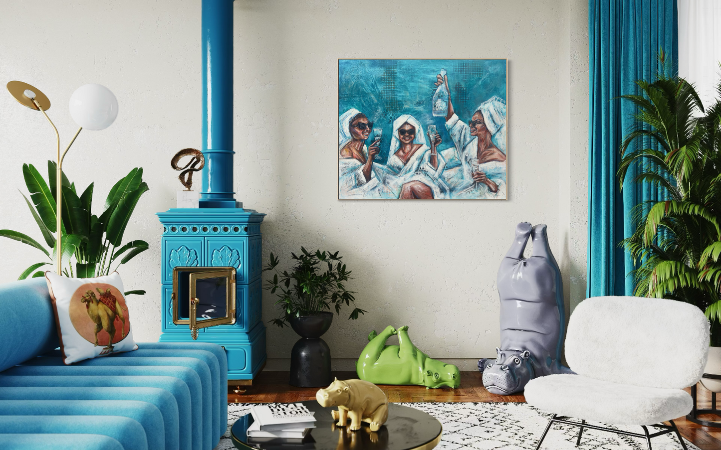 A framed painting of "Cheers To Us" depicting three figures in white robes against a blue background, hanging on a white wall in a styled living room with a turquoise wood-burning stove, plants, and modern furniture.