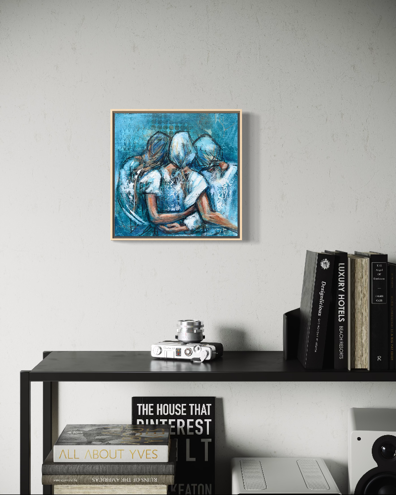 A framed abstract painting of three figures in blue tones hangs on a light grey wall above a black shelf with books and a camera.