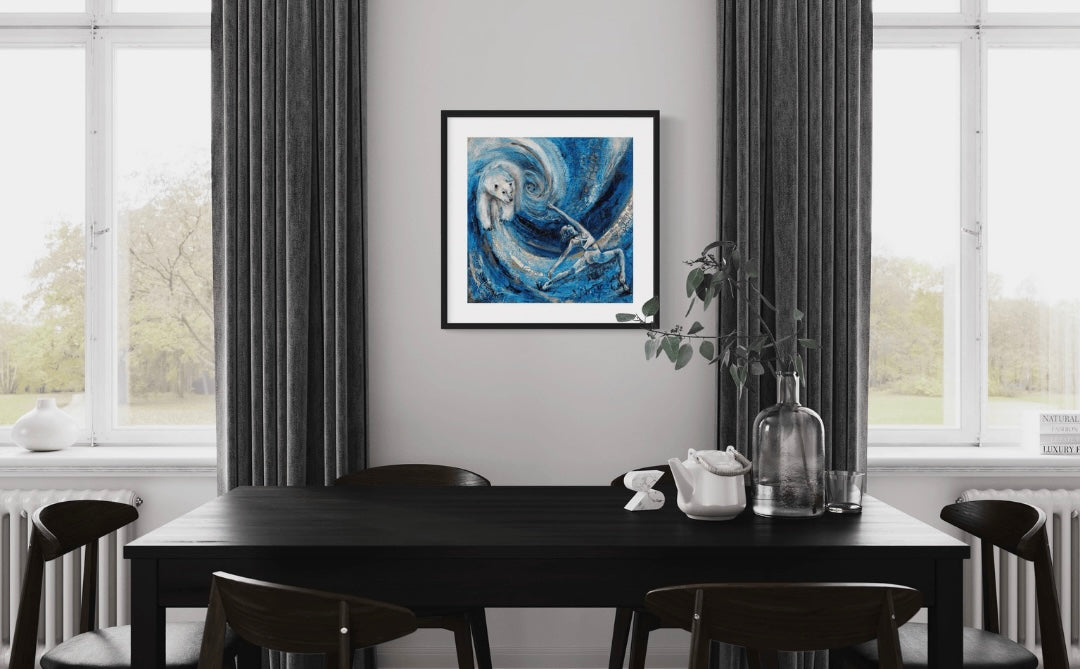 A painting featuring a stylized depiction of a woman and a polar bear against a blue background with swirling patterns. The woman appears to be in a warrior pose, and the polar bear is facing her. The painting is featured in a modern black and white and grey dining area.