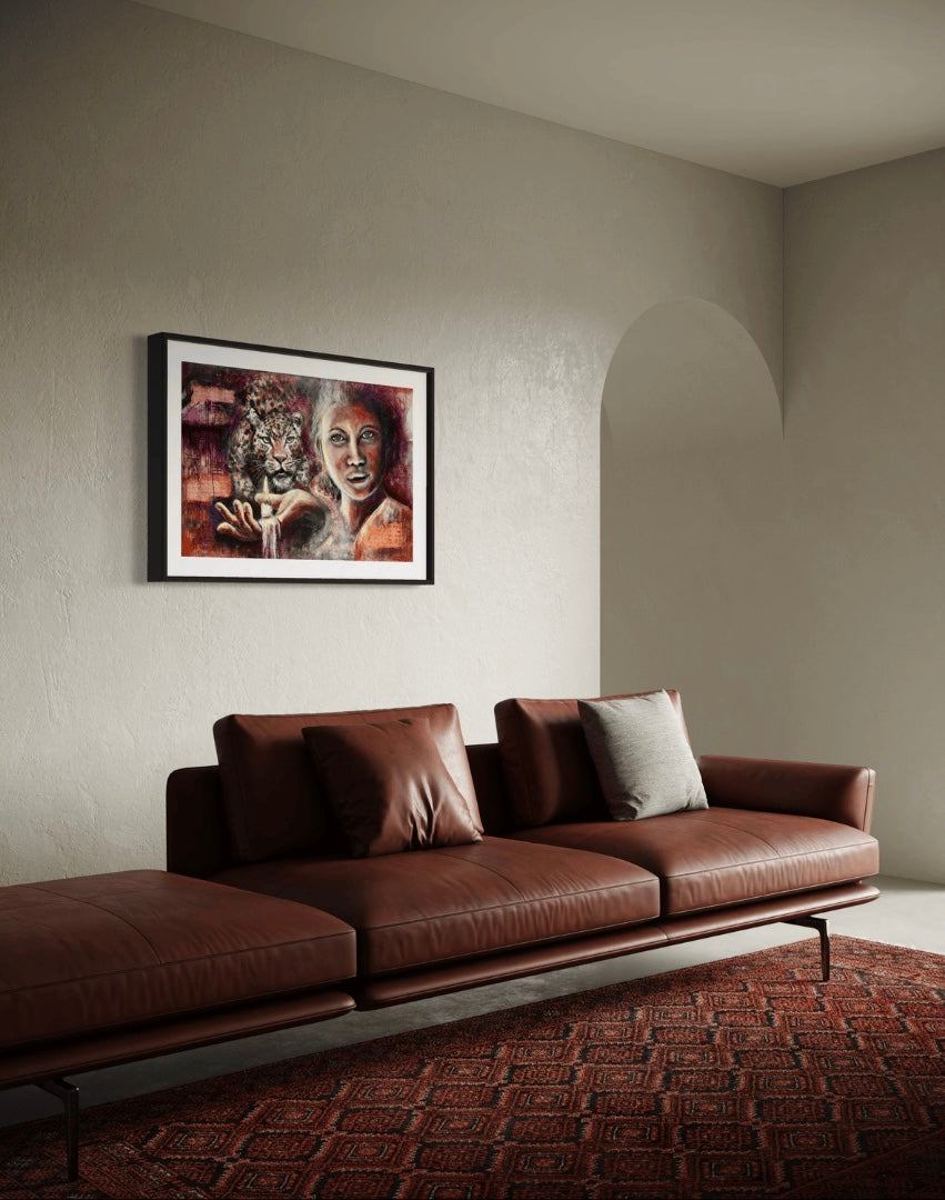 The artwork titled shining light of a leopard and lady holding up a candle light in her hand in front of a brown leather couch and red rug.