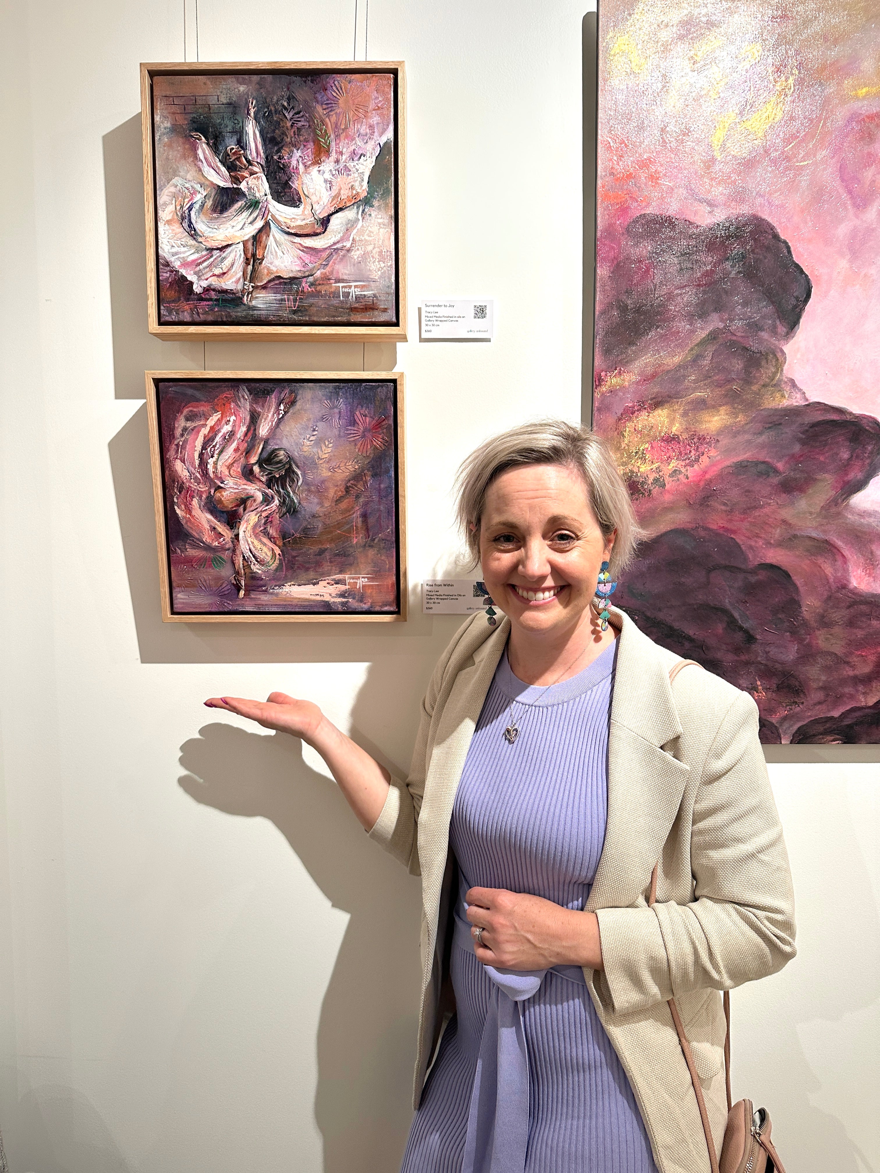 Mixed media Melbourne artist Tracy Lee Warusevitane stands in front of her freedom dancing paintings at Gallery Unbound. It shows the two dancers Surrender to Joy and Rise from Within.