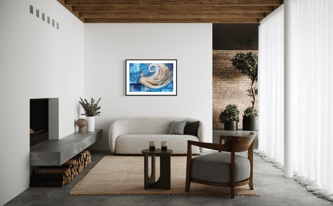 Modern living room with sheer curtains and a fireplace and natural elements of wood and brick features the painting "whirlwind of Elegance" a blue and gold abstract dancer painting featuring real feathers, framed with a black frame and white mount. 