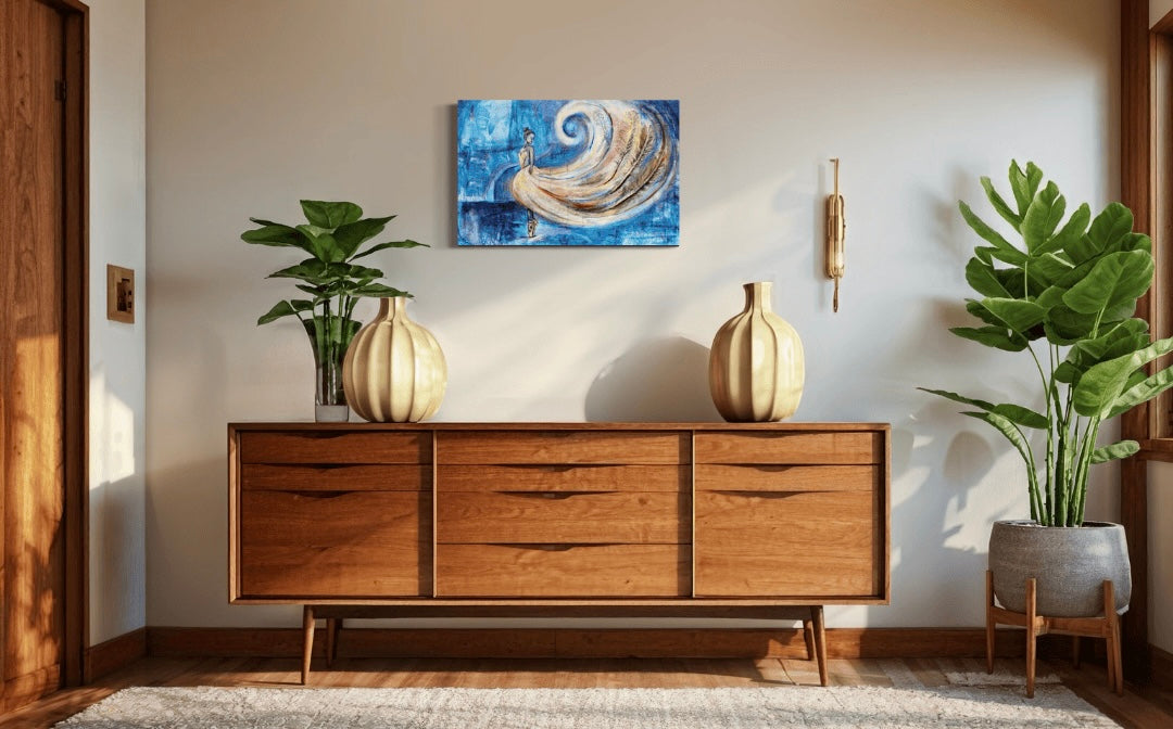 A hallway or living room with wooden furniture and plants featuring the painting Whirlwind of Elegance, a ballet dancer with flowing dress and real feathers.