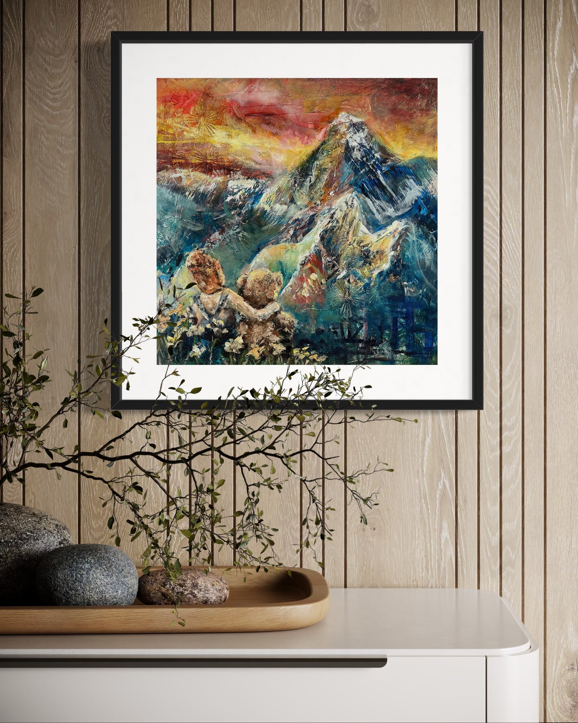Framed abstract painting of a mountain scene with children on a wooden wall.